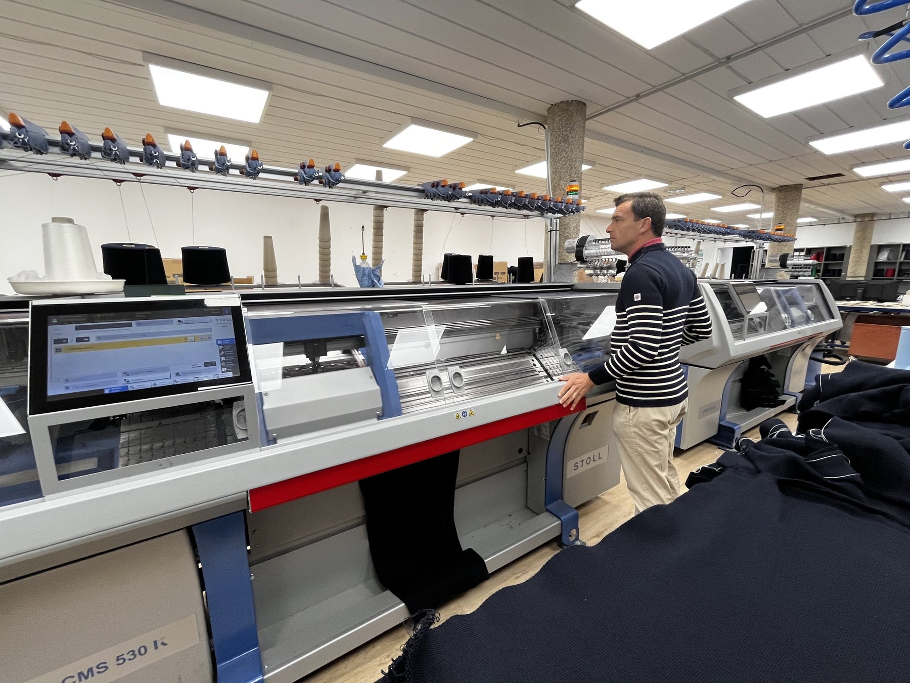 Geoffroy, fondateur, devant une machine à tricoter Stoll dans l'atelier Baie des Caps à Beaussais-sur-Mer